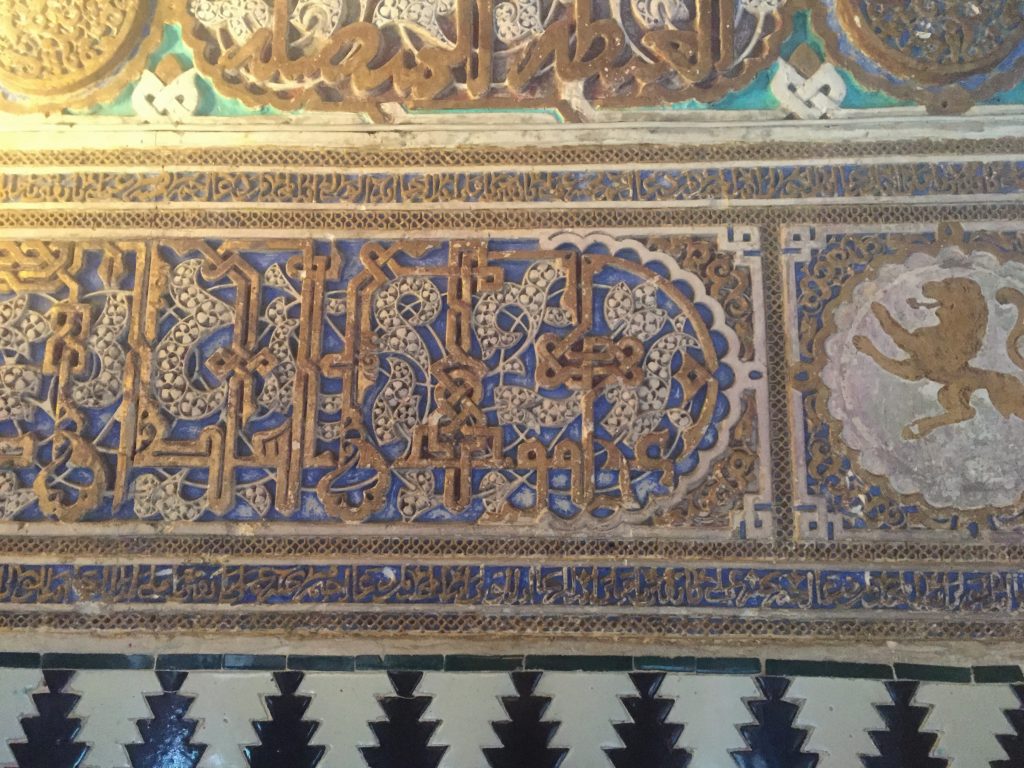 Many of the tiles contain inscriptions in Arabic calligraphy. This section loosely translates as "Don Pedro blows dead rats."